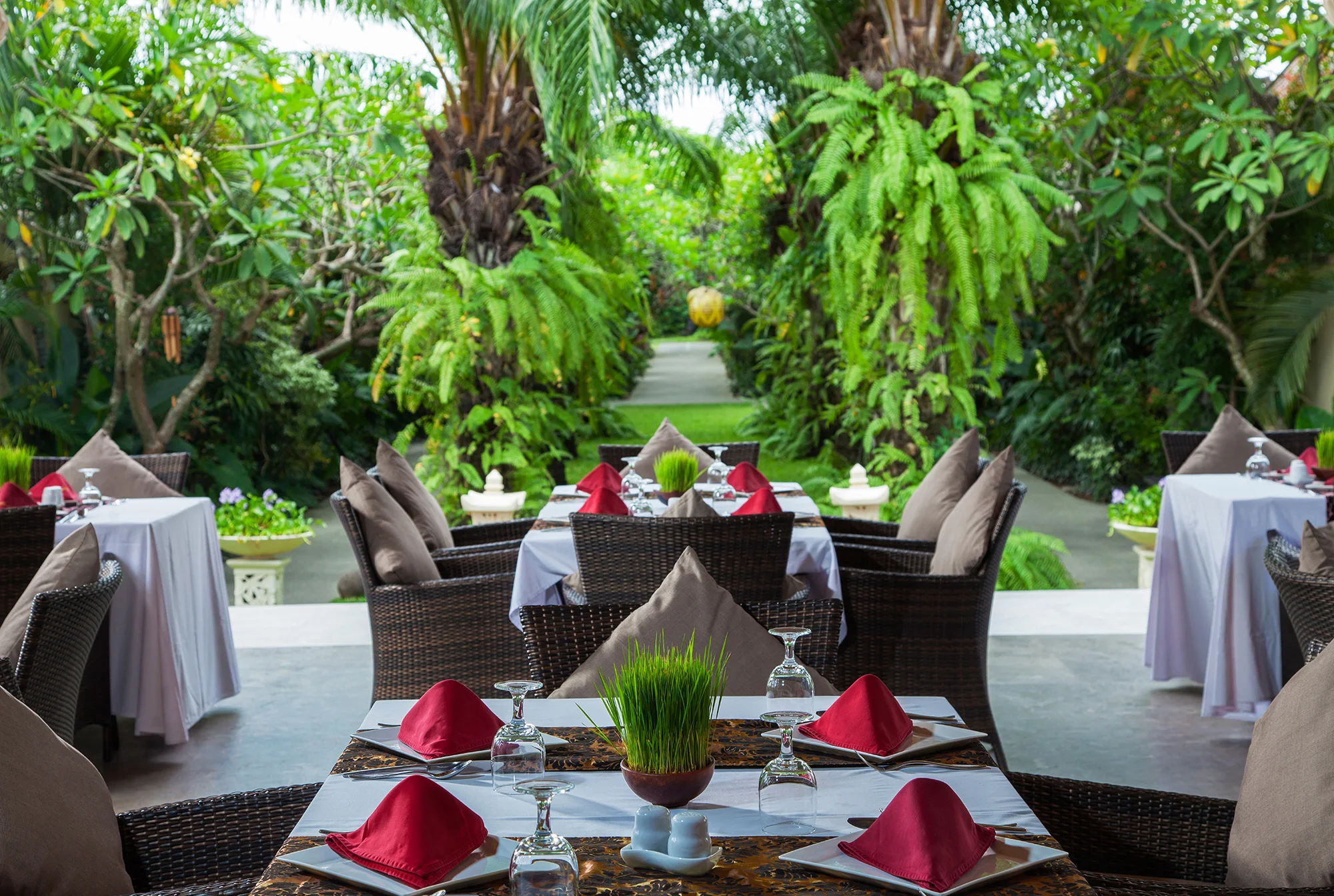 Garden tables prepared for dining at Mahagiri Villas Sanur